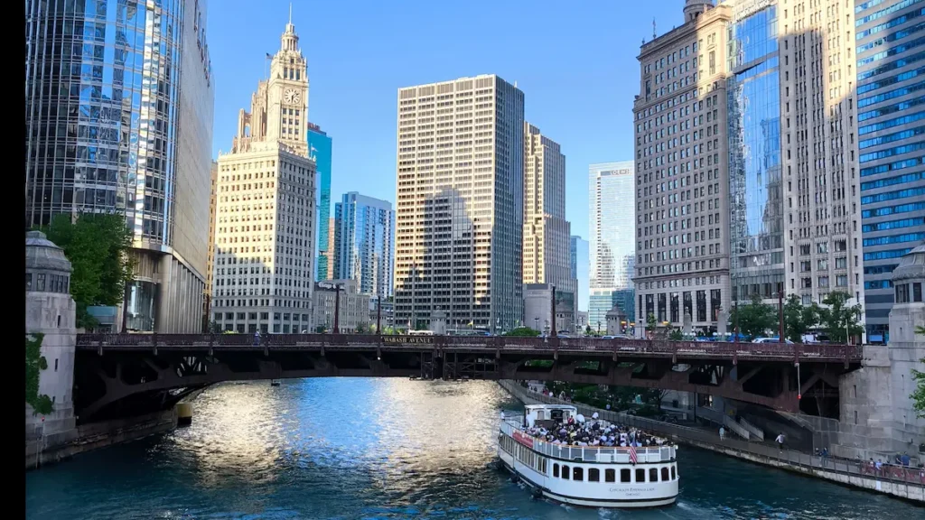 Barco de crucero de arquitectura navegando por el río Chicago rodeado de rascacielos en Estados Unidos