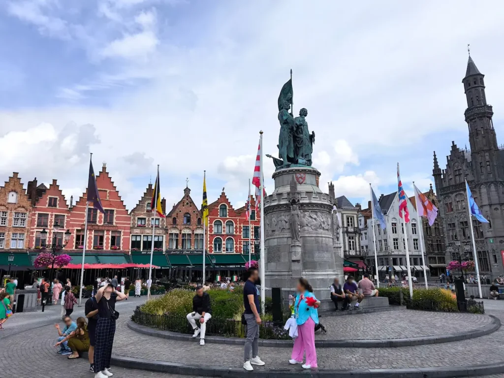 La Grote Markt con la estatua de los héroes de Flandes y las casas gremiales en Brujas